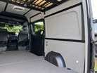 Pre-wrapped side wall panels and L-Track in a Sprinter, view toward the cab