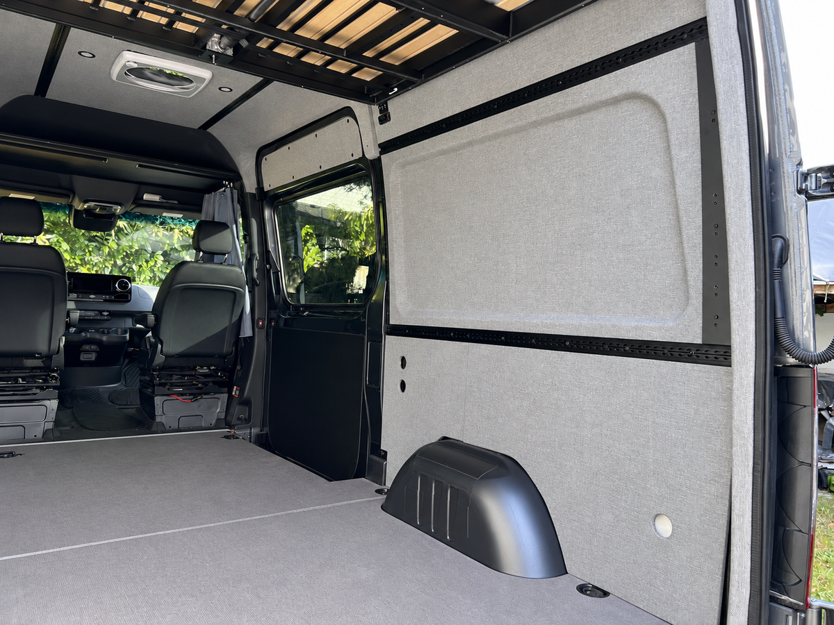Pre-wrapped side wall panels and L-Track in a Sprinter, view toward the cab