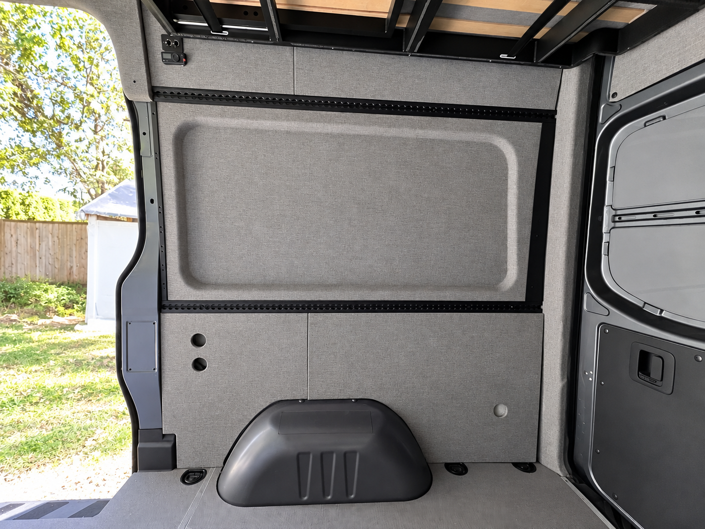 Pre-wrapped Sprinter wall panel and L-Track next to the sliding door